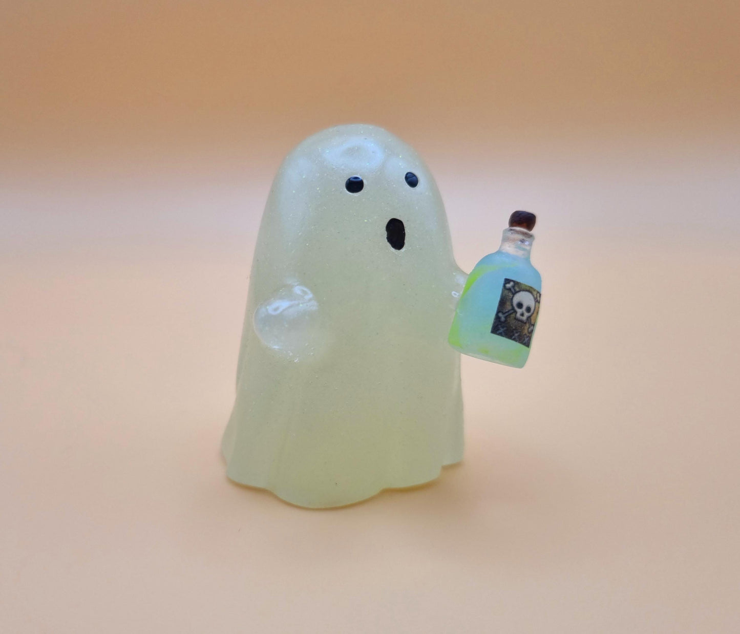Cute night glow ghost with little blue and green poison bottle with skull on it on orange background side view