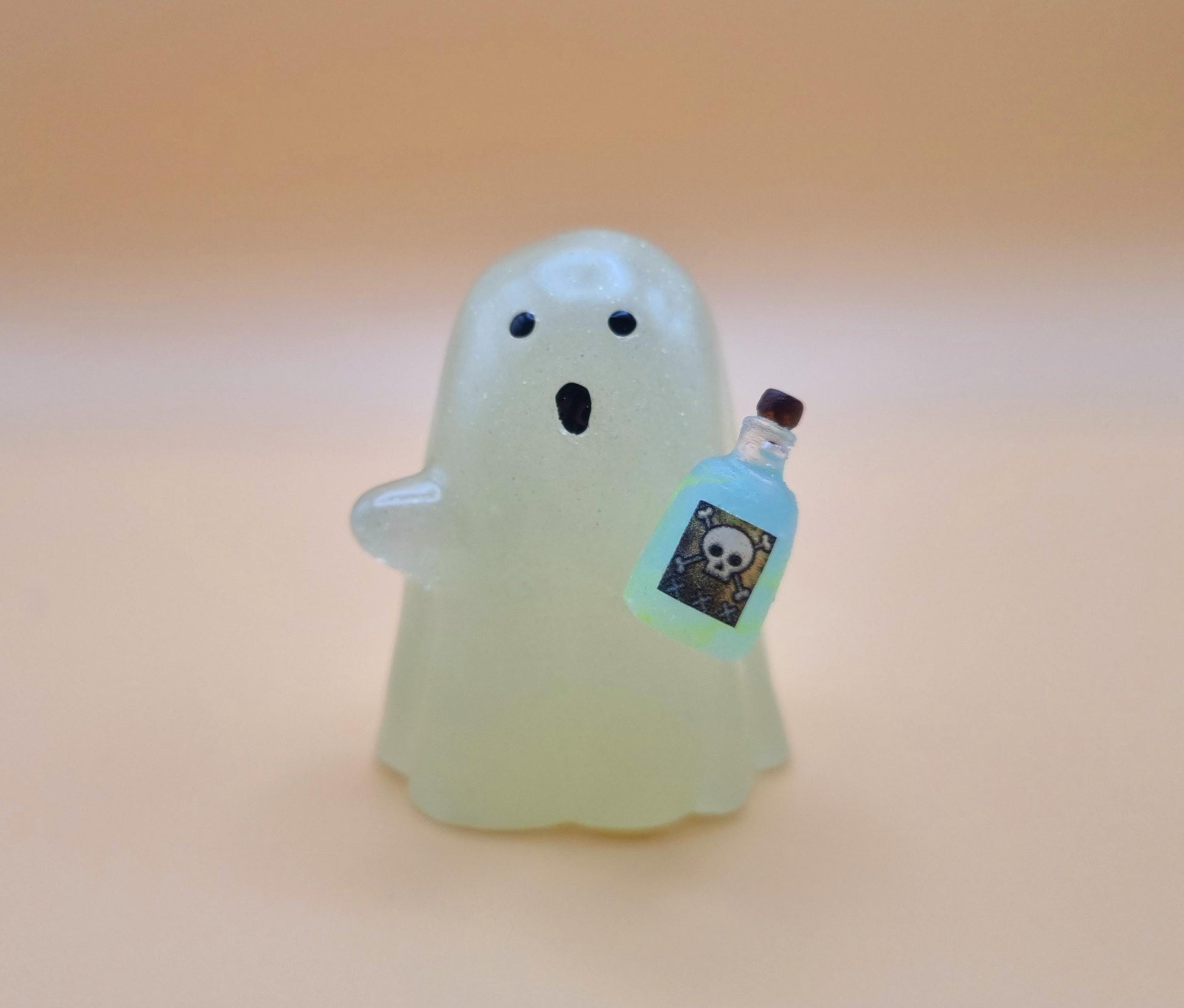 Cute night glow ghost with little blue and green poison bottle with skull on it on orange background 